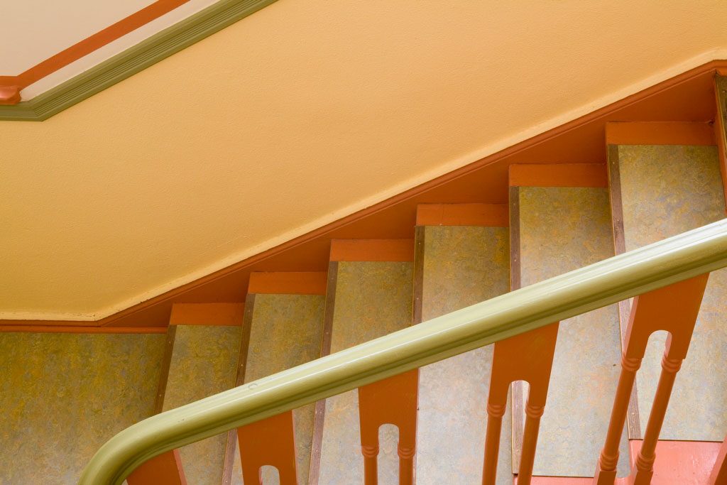 Neu gestaltetes Treppenhaus mit orangefarbenen und grünen Farbbändern