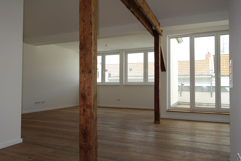 Wohnraum mit Holzstützen und Fenstertür zur Terrasse