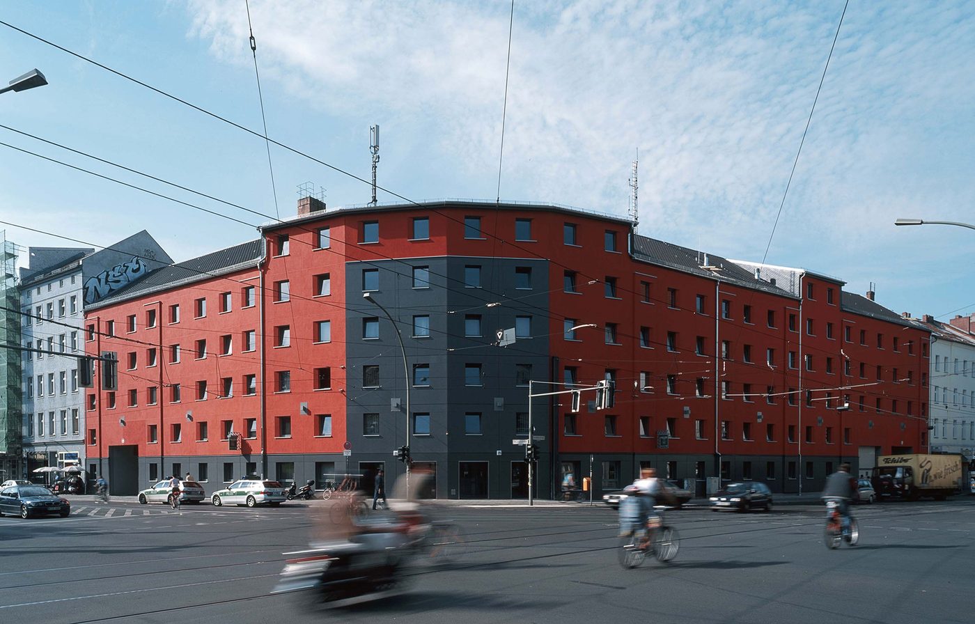 Verwaltungsgebäude der Polizei Berlin in Mitte: rot gestrichener Plattenbau an einer Straßenkreuzung